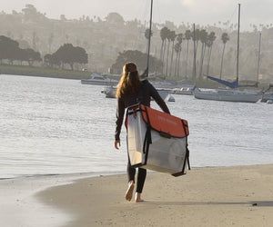 Woman carrying her Coast XT Kayak folded 
