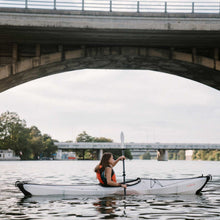 woman on the river paddling in her bay st kayak and using the oru paddles.