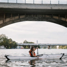 woman on the river paddling in her bay st kayak and using the oru paddles. 