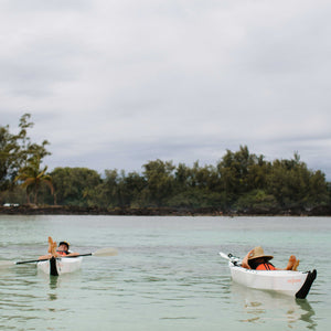 Two people relaxing inside their beach lt kayak on water 