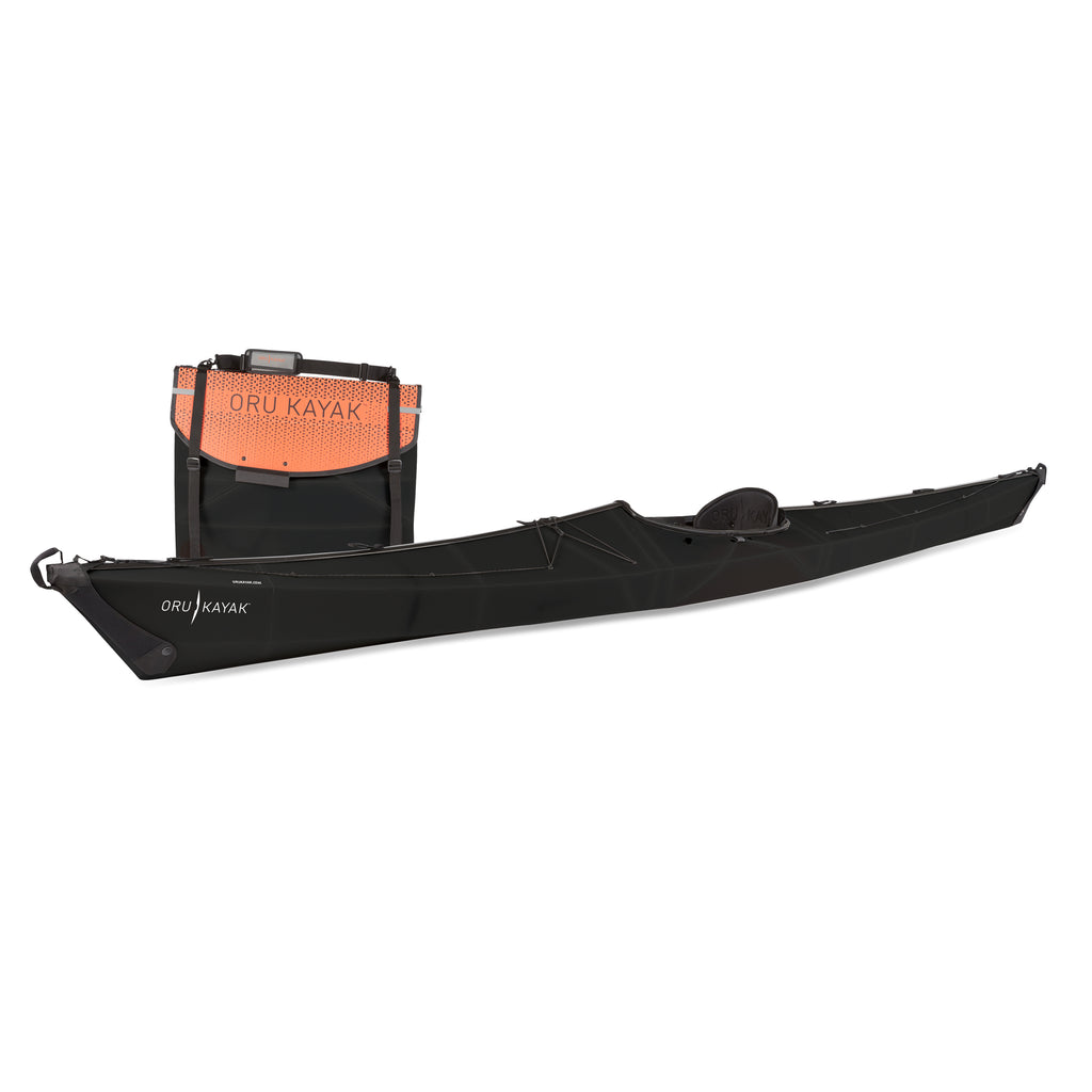 Side view of the Oru Kayak Coast model in black, shown fully assembled in front of its compact folded box form.